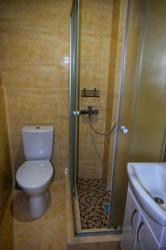 y baño con ducha, aseo y lavamanos. en Man Apartment en Chernivtsi