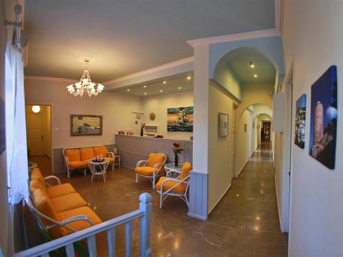 Theano Guesthouse في هيدرا: مدخل مع كراسي برتقالية وغرفة انتظار