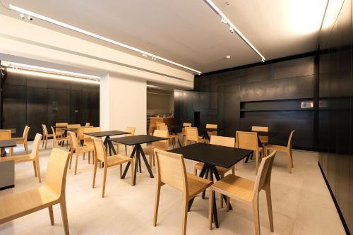 a dining room with black tables and chairs at Hotel Touring in Ferrara