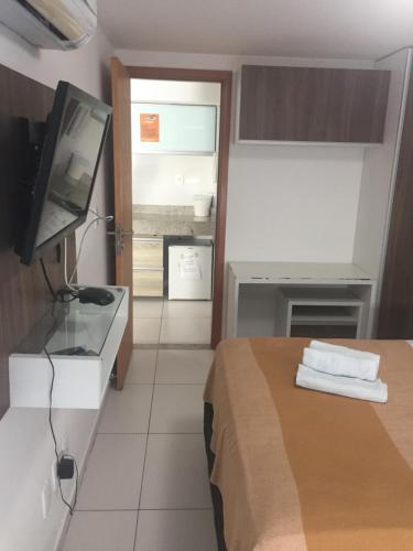 a hotel room with a bed and a television at Melhor ponto turístico de Jampa Ap 119 in João Pessoa