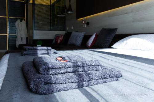 a bed with a pile of towels on top of it at Luxury apartments «Love Story» in Ivano-Frankivsʼk