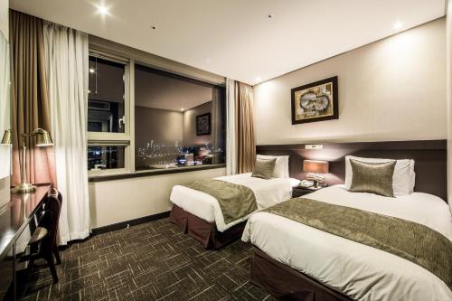 a hotel room with two beds and a window at Golden Seoul Hotel in Seoul