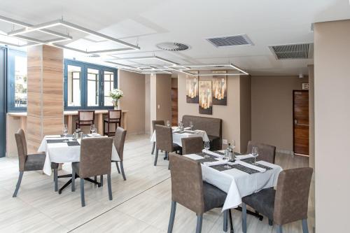 a restaurant with tables and chairs in a room at LOCH LOGAN HOTEL in Bloemfontein