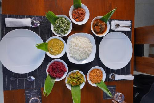 a table with white plates of food on it at Monaara Leisure - Anuradhapura in Anuradhapura