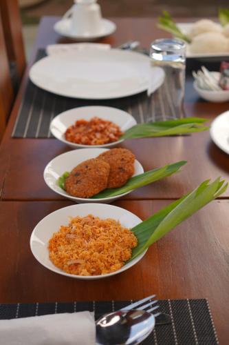 a wooden table with plates of food on it at Monaara Leisure - Anuradhapura in Anuradhapura