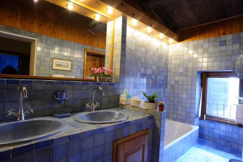 a bathroom with two sinks and a tub at Corte Beatrice in Novaglie