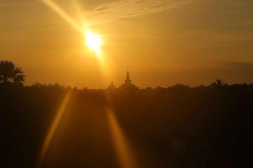 a sunset with the sun setting in the background at Monaara Leisure - Anuradhapura in Anuradhapura