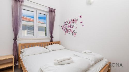a bedroom with two beds and a window at Rona apartments Goran in Šimuni
