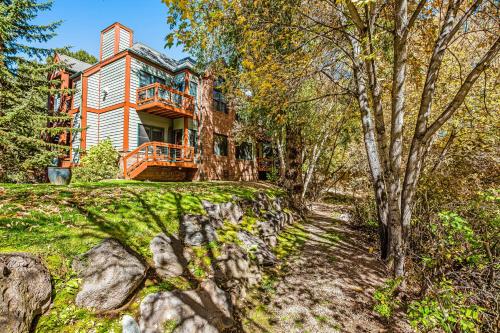 a house on a hill with trees in front of it at Mountain Retreat in Basalt