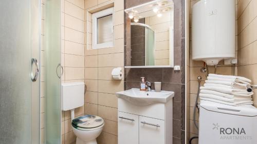 a small bathroom with a sink and a toilet at Rona apartments Goran in Šimuni