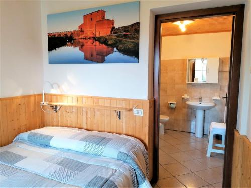 a bedroom with a bed and a bathroom with a sink at Agriturismo Galeazzi in Marsiliana