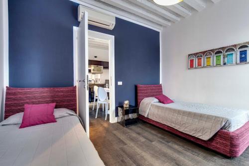 a bedroom with two beds and a blue wall at Biennale superior suite in Venice