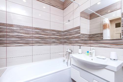 uma casa de banho branca com um lavatório e uma banheira em Современная квартира в новом ЖК Центр с парковкой em Novosibirsk