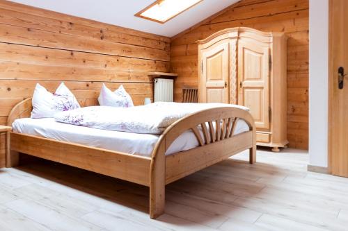 ein Schlafzimmer mit einem Bett in einem Holzzimmer in der Unterkunft Hafnerhof in Einöden