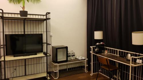 a living room with a television and a table with a chair at M Boutique Hotel Station 18 - Ipoh in Ipoh
