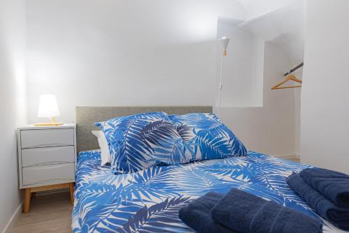 a bedroom with a bed with blue sheets and pillows at Vence...sur les pas de Matisse in Vence