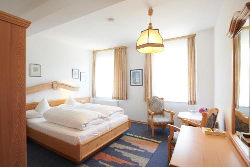 1 dormitorio con cama, escritorio y silla en The Conscious Farmer Bed and Breakfast Sauerland, en Willingen