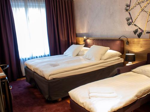 a hotel room with two beds and a window at Original Sokos Hotel Vaakuna Kouvola in Kouvola