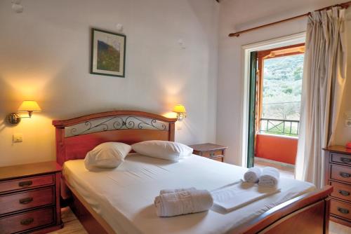 a bedroom with a bed with two towels on it at Magda Hotel Apartments in Ancient Epidauros