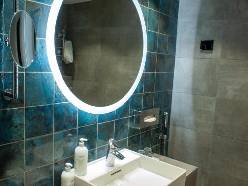 a bathroom with a sink and a mirror at Original Sokos Hotel Vaakuna Kouvola in Kouvola
