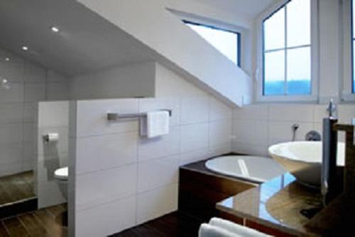 a bathroom with a sink and a bath tub at Hotel Restaurant Café Rapp in Königsfeld im Schwarzwald