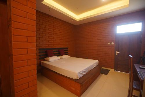 a bedroom with a bed in a brick wall at Monaara Leisure - Anuradhapura in Anuradhapura