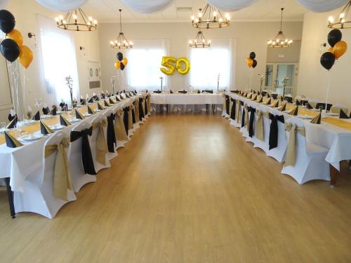 a banquet hall with white tables and chairs and balloons at Tom&Tom in Białogard