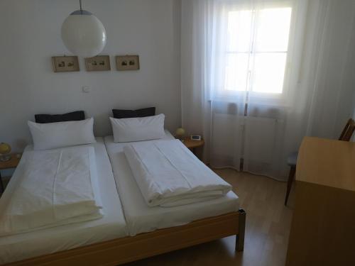 1 dormitorio con 2 camas blancas y ventana en Thermen-Residenz, en Bad Füssing