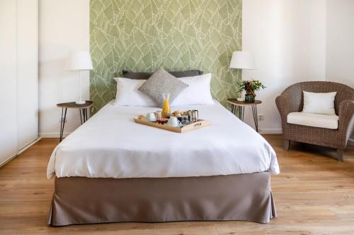 - une chambre avec un grand lit et une chaise dans l'établissement Hôtel & Séminaire Le Patio Occitan - Toulouse Ouest - Francazal, à Cugnaux