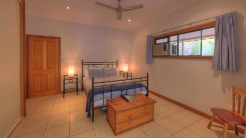Un dormitorio con una cama y una mesa. en Magnetic Island Bed and Breakfast en Horseshoe Bay