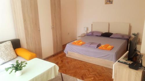 a bedroom with a bed and a table and a television at Central Apartment in Silistra