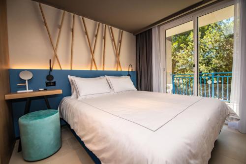 a bedroom with a large bed and a window at Arena Verudela Beach in Pula