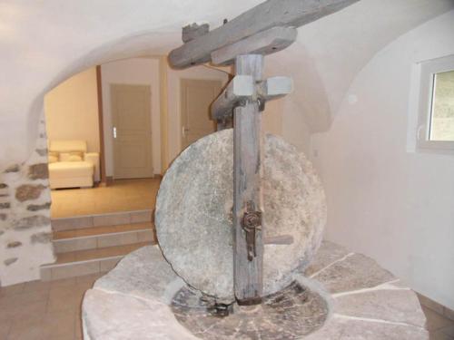 a large stone object in a room with a staircase at Le gîte du Jas Vieux in Montfort