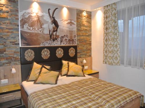 a bedroom with a bed with a deer on the wall at Hotel Baumgartnerhof in Altfinkenstein