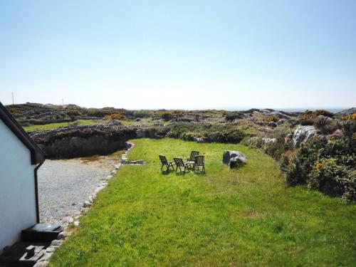 two chairs and tables sitting in a field of grass at Cnocan Na Cuaig Carraroe by Trident Holiday Homes in Carraroe