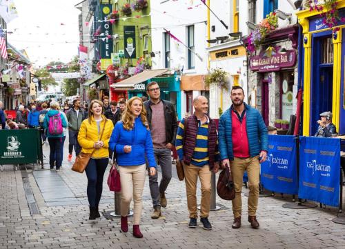 a group of people walking down a street at Cnocan Na Cuaig Carraroe by Trident Holiday Homes in Carraroe