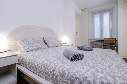a bedroom with a white bed with two towels on it at Downtown Como-Porta Torre Flat in Como