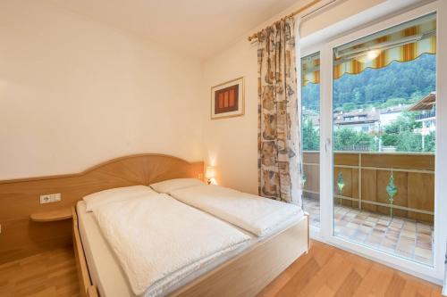 ein Schlafzimmer mit einem Bett und einem großen Fenster in der Unterkunft Residence Kronstein - Fewo 4 in Tisens