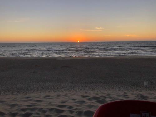 una puesta de sol en la playa con el océano en Apartamento F.A, en Pedrógão