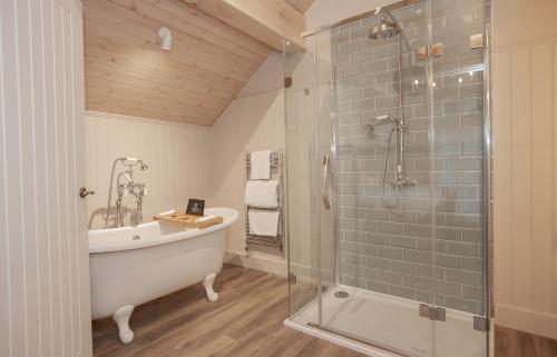 a bathroom with a tub and a glass shower at The Lion at Malpas in Malpas