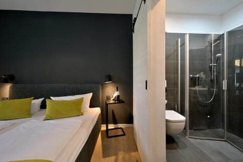 ein Schlafzimmer mit einem Bett, einer Dusche und einem WC in der Unterkunft Hotel- & Ferienanlage Kapitäns-Häuser Breege in Breege