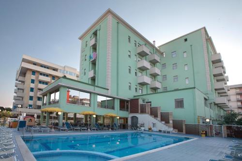 a hotel with a swimming pool in front of a building at Hotel Abacus in Cesenatico