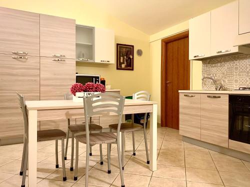 una cucina con tavolo, sedie e lavandino di Mapma a Castrovillari