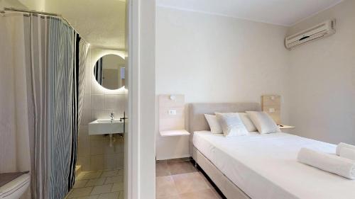 a white bedroom with a bed and a sink at Kiperi Exclusive in Parga