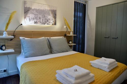 a bedroom with a bed with towels on it at BenB Het Posthuis in Nispen