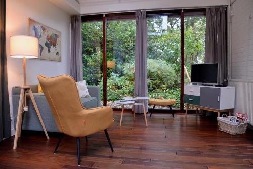 a living room with a couch and a television at BenB Het Posthuis in Nispen