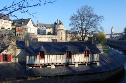 a house with red windows in front of a castle at ibis budget Vannes in Vannes