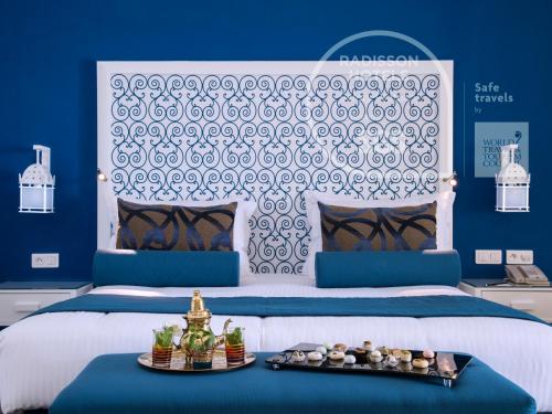 a bedroom with a large bed with a blue wall at Radisson Blu Resort & Thalasso Hammamet in Hammamet