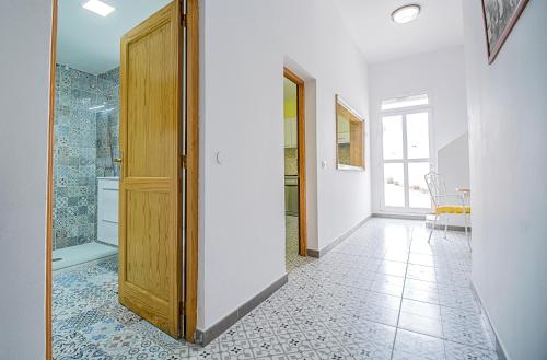 un pasillo con una puerta que conduce a un baño en Casa de los Dragos, en Gáldar