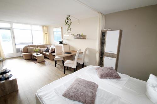 um quarto com uma cama branca e uma sala de estar em Ferienpark O04-003 Ferienpark em Heiligenhafen